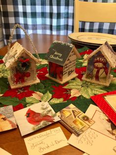 christmas cards are laid out on the dining room table with bird houses and cardinal decorations