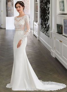 a woman in a white wedding dress posing for the camera with her hands on her hips