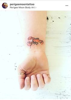 a small crab tattoo on the wrist