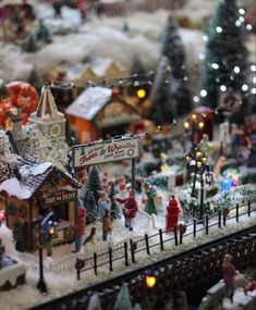 a christmas village is shown with people walking around