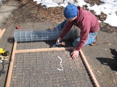 a man is working on some kind of metal grate in the snow with tools