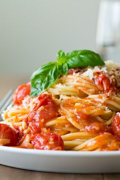 a plate of pasta with tomato sauce and basil