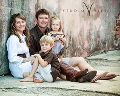 a family posing for a photo in front of a wall