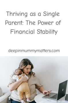 a woman holding a baby in her arms while sitting at a desk with a laptop