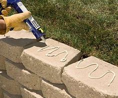 a person using a power drill to fix a brick wall