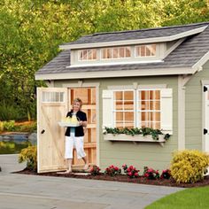 a young boy standing in the doorway of a small shed