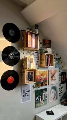 there are many records on the wall with plants growing out of them in this room