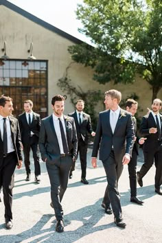 a group of men in suits walking down a street