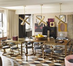 a dining room table and chairs with artwork on the wall