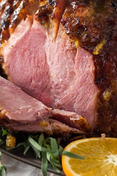 sliced ham on a plate with broccoli and carrots in the foreground