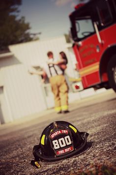 a fireman's helmet laying on the ground next to a fire truck