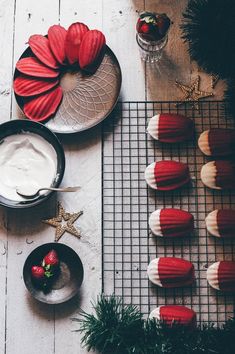 red and white cupcakes are on a wire rack next to other dessert items