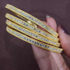 "* Handcrafted Gold Plated 4 Bangle Set. Sold as a set. * Bangles with high quality CZ stones. * High Quality 22K Gold Plated. Bangles Sizes : 2.4 inches= ( 2.25\" diameter of the inner circle) ; 2.6 inches = ( 2.39\" diameter of the inner circle); 2.8 inches = (2.54\" diameter of the inner circle) The gorgeous gold-plated bangles set best exemplifies the careful craftsmanship done on it -- specially picked for you by Nemali Jewelry. It has a special tone of elegance attached to it. The intricat Gold Bling Bangle Gift, Dazzling Gold Jewelry With Stone Work, Gold Festive Jewelry With Bling, Gold Adjustable Bridal Sets, Adjustable Gold Bridal Sets, Sparkling Gold Jewelry For Festive Occasions, Festive Gold Bling Jewelry, Festive Sparkling Gold Jewelry, Gold Bracelets With Stone Work For Anniversary