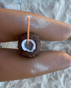 a person holding a coconut drink with a straw sticking out of it's center