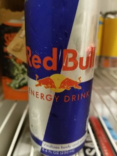 a can of red bull energy drink sitting on top of a refrigerator