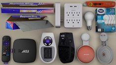 an assortment of electronic gadgets are arranged on a table with remotes and other items