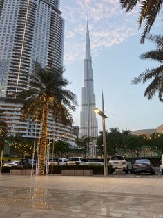 the burj building is surrounded by palm trees and other tall buildings in the background