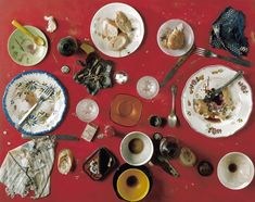 an assortment of dishes and utensils laid out on a red table