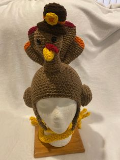 two knitted turkey hats sitting on top of a white mannequin's head