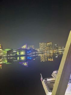 the city skyline is lit up at night with lights reflecting in the water and buildings on both sides