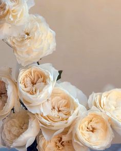 a vase filled with lots of white flowers on top of a blue cloth covered table