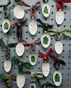 spoons with christmas decorations are hanging on a peg board