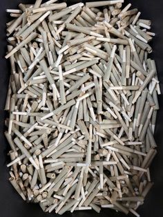 a pile of white sticks sitting on top of a black table next to each other