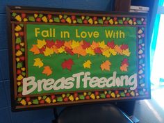 a sign that says fall in love with breastfeeding and leaves on green background