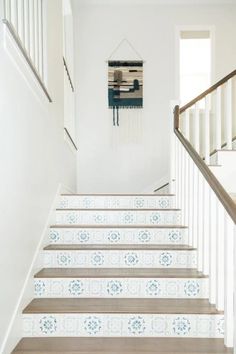 the stairs are painted with blue and white tiles on them, along with wooden handrails