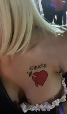 a woman with a tattoo on her chest that reads chucky and has a knife in it