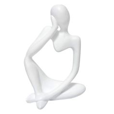 a white statue sitting on the ground with its legs crossed and hands behind her head