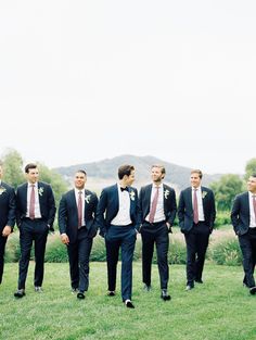 a group of men standing next to each other on top of a lush green field