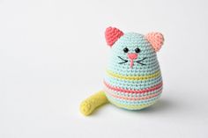 a crocheted cat toy sitting on top of a white table next to a yellow object