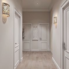 an empty hallway with white doors and wood flooring is seen in this image, there are two lights on either side of the door