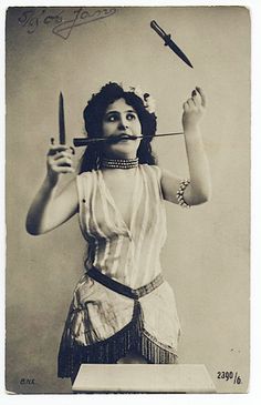 an old photo of a woman with scissors in her hair and holding a knife above her head