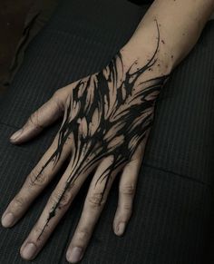 a person's hand with black ink splattered on the arm and wrist