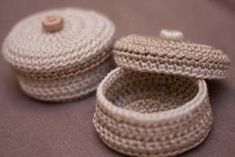 two crocheted baskets sitting next to each other on top of a purple surface