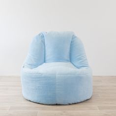 a blue bean bag chair sitting on top of a hard wood floor next to a white wall