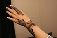 a woman's hand with henna tattoos on it