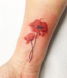 a red flower tattoo on the wrist