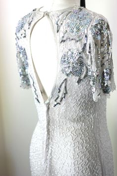 "This is a simple and very sparkly dress!! The silver on it really stands out against the white and it really is a beauty! the back has a keyhole opening with a zipper. Very Good condition! Measuring: 39\" long Bust: 36\" Waist: 30\" Hip: 36\" Beaded, sequins with some pearl beads as well.. Pet Free/smoke free Enjoy!" White Fitted Sequin Dress For Gala, White Sequined Evening Dress For Gala, White Backless Sequin Prom Dress, Sparkling Backless Sequin Dress For Wedding, Backless Sparkling Sequin Dress For Wedding, Sparkling Backless Sequin Wedding Dress, Backless Sparkling Sequin Wedding Dress, Elegant White Sequin Dress For Prom, White Backless Sequin Dress