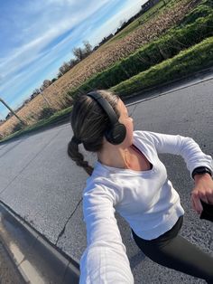 a woman riding a skateboard with headphones on