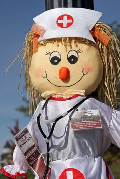 a scarecrow dressed as a nurse with a red cross on it's head