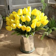 a vase filled with yellow flowers on top of a table