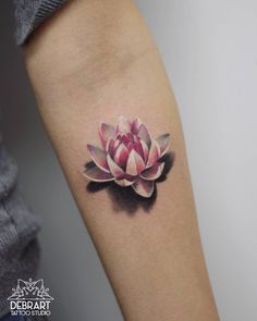 a pink flower tattoo on the arm