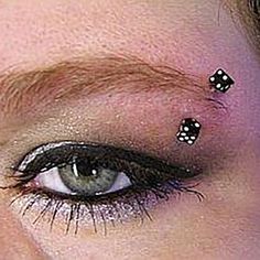 a close up of a person with black and white dots on their eyeliners