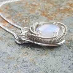 "You want it and you know who you are. This Rainbow Moonstone pendant is wire wrapped in sterling silver. Moonstone holds within it the deep seated nature of feminine energy, which is said to help balance the masculine-feminine vibrations within your body and nurture your spirit. I'm offering this amazing piece together including chain for only 250. 📖 A 𝗹𝗲𝗴𝗲𝗻𝗱 𝗳𝗿𝗼𝗺 𝗦𝗿𝗶 𝗟𝗮𝗻𝗸𝗮 says that a moon like stone occurred deep in the earth, and that on a night like this when the moon was Sterling Silver Wire Wrapped Round Pendant Jewelry, Sterling Silver Wire Wrapped Round Pendant, Spiritual Wire Wrapped Sterling Silver Jewelry, Nature-inspired Sterling Silver Wire Wrapped Necklaces, Nature-inspired Wire Wrapped Sterling Silver Necklaces, Nature-inspired Sterling Silver Wire Wrapped Jewelry, Sterling Silver Hand Wrapped Necklace For Gift, Silver Wire Wrapped Moonstone Necklace, Silver Wire Wrapped Moonstone Jewelry