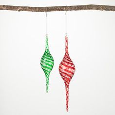 two christmas ornaments hanging from a tree branch