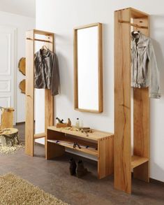 a wooden bench sitting under a mirror next to a coat rack