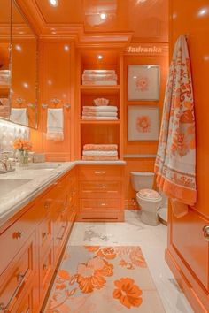 a bathroom with orange walls and flooring, white counter tops and drawers on both sides